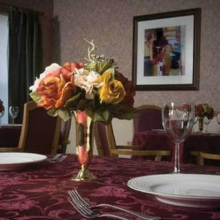 A elegantly set dining table with a floral centerpiece.