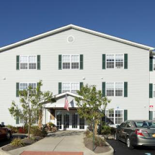 A welcoming building with a well-maintained entrance and clear blue sky overhead.