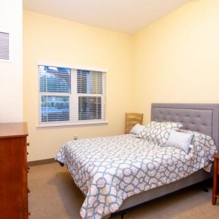 A cozy bedroom with a neatly made bed and soft lighting.