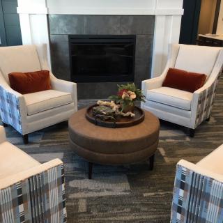 A cozy living room setup with armchairs, a central coffee table, and a fireplace.