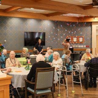 A lively gathering of seniors in an activity room, enjoying social interactions and activities.