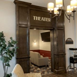 Entrance to a cozy home theater with plush seating and elegant lighting.