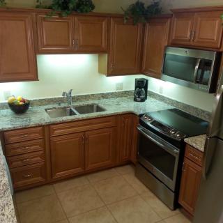 A modern kitchen with wooden cabinets and stainless steel appliances.