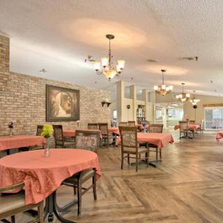 A cozy dining area featuring elegant chandeliers and warm brick accents, perfect for gatherings.