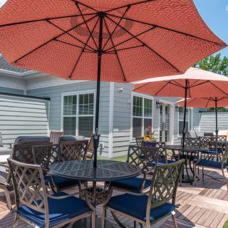 A spacious outdoor patio with tables, chairs, and umbrellas.