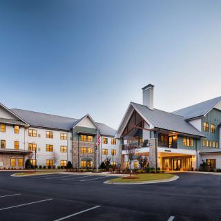 A modern building with a pitched roof design, taken during the evening.