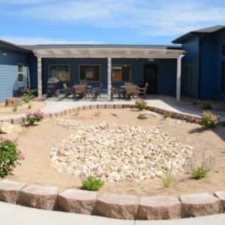 A desert-style garden with rocks and shrubs in the courtyard of a house.