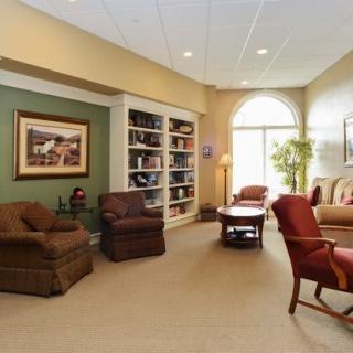 A cozy living room with comfortable seating, a bookshelf, and natural lighting.