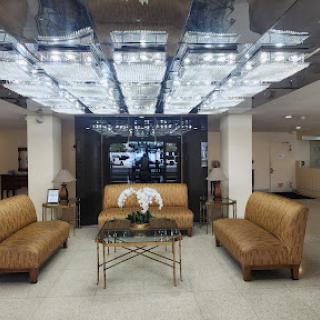 A contemporary lobby featuring stylish leather sofas, modern decor, and elegant lighting.
