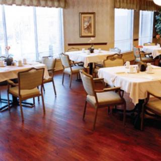 A cozy dining area with neatly arranged tables and chairs, featuring elegant decor.