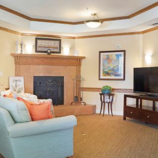 A cozy living room featuring a fireplace, comfortable sofa, and a television.