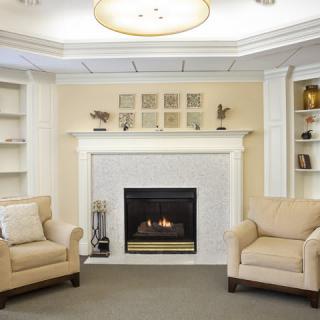 A cozy living room with a fireplace and comfortable armchairs.