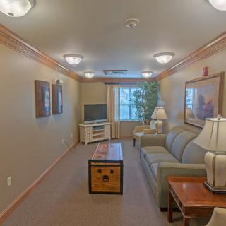A cozy living room with a sofa, coffee table, and TV setup.