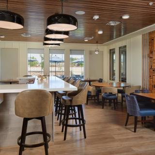 A modern restaurant interior featuring a spacious dining area with stylish seating and wooden decor.