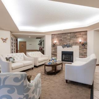 A stylish and cozy living room featuring white furniture, a warm fireplace, and modern decor.