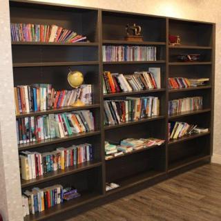 A well-stocked bookshelf filled with a variety of books.