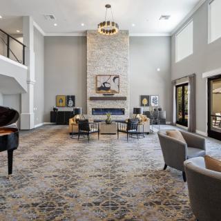 Spacious modern lounge with a grand piano and fireplace.