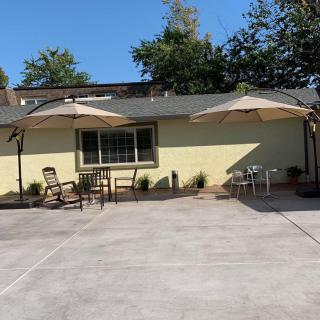 A sunny patio area with tables and chairs under large umbrellas.