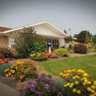 A charming house surrounded by a vibrant garden full of colorful flowers.