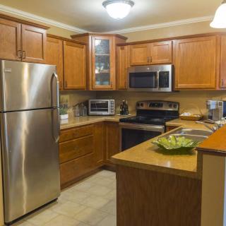 A modern kitchen with wooden cabinets and stainless steel appliances.