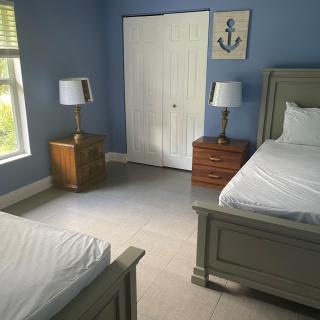 A bedroom with twin beds and nautical-themed decor.