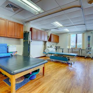 A spacious rehabilitation room equipped for physical therapy sessions.