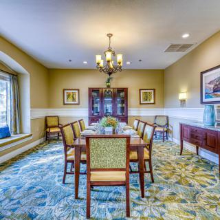 A well-decorated dining room with a chandelier, elegant furniture, and wall art.
