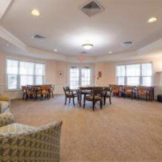 A spacious, well-lit room with multiple tables and chairs arranged in an inviting manner.