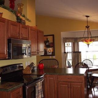 A cozy kitchen featuring wooden cabinets, modern appliances, and a welcoming dining area.