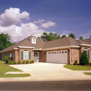 A suburban brick house with a driveway and attached garage.