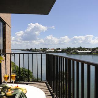 A relaxing balcony with a scenic river view and outdoor dining setup.