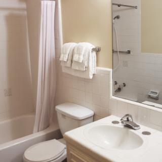 A clean and simple bathroom featuring a shower, toilet, and sink.