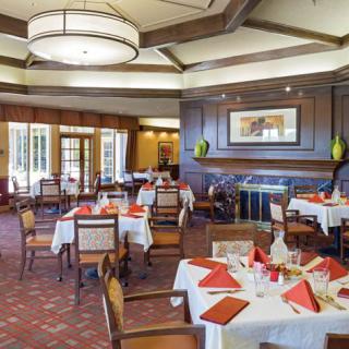 A neatly arranged restaurant dining area with tables and chairs, showcasing elegant interior design.