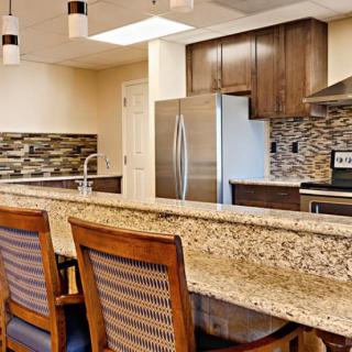 A modern kitchen with granite countertops, stainless steel appliances, and a tile backsplash.