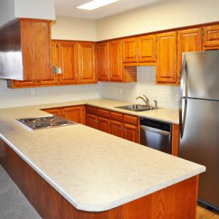 A modern kitchen with wooden cabinets and stainless steel appliances.