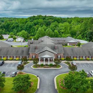 Aerial view of a large building surrounded by lush greenery and trees.