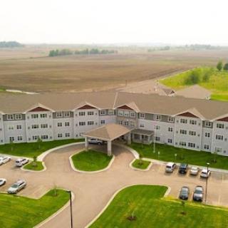 Aerial view of a residential building surrounded by open fields.