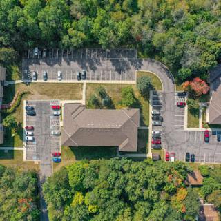 Aerial view of a suburban parking lot surrounded by greenery.