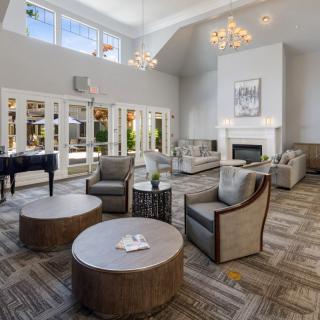 A luxurious living room with modern furnishings, featuring a cozy fireplace and elegant chandeliers.