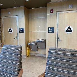 A view of a waiting area featuring restrooms and water fountains.