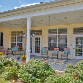A cozy porch with colorful chairs and a garden view.
