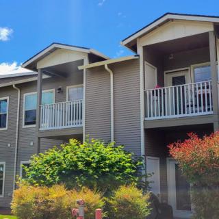 A modern apartment building with balconies under a clear blue sky.
