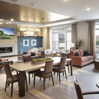 A modern open-concept living and dining area with stylish furniture and a cozy fireplace.