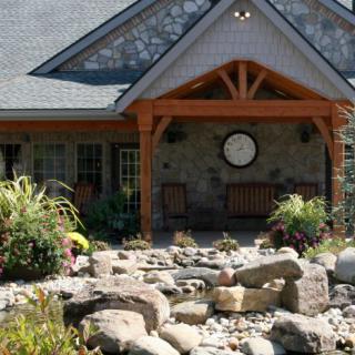 Front view of a house with a landscaped garden and rock formations.