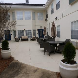 A courtyard with patio furniture and potted plants outside a building.