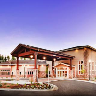 A modern building showcasing sleek architecture and a welcoming entrance set against a twilight sky.