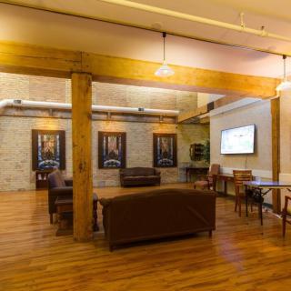 A cozy lounge area with comfortable seating, wooden flooring, and contemporary artwork on the walls.