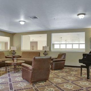 A spacious living room featuring comfortable seating and a piano.