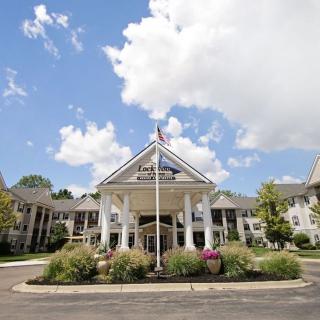 Elegant hotel entrance with columns and landscaped surroundings.