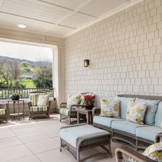 A cozy outdoor patio with comfortable seating and a scenic view.